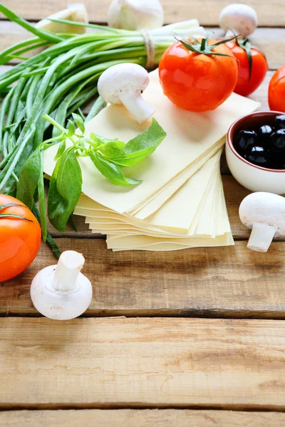 Lasagna and ingredients, mushrooms, tomatoes, greens — Stock Photo, Image
