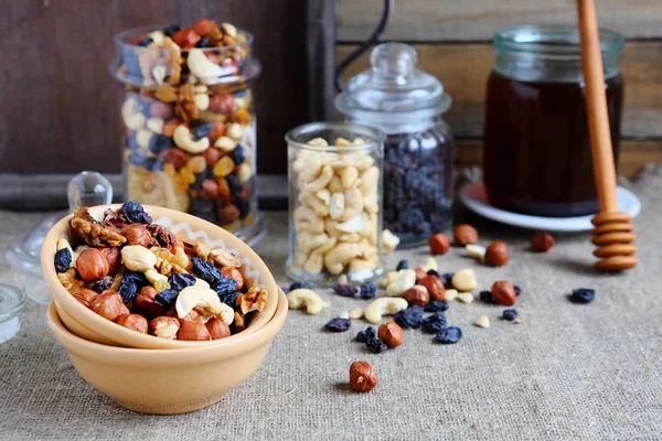 Mix nuts in a bowl on the table and jar — Stock Photo, Image