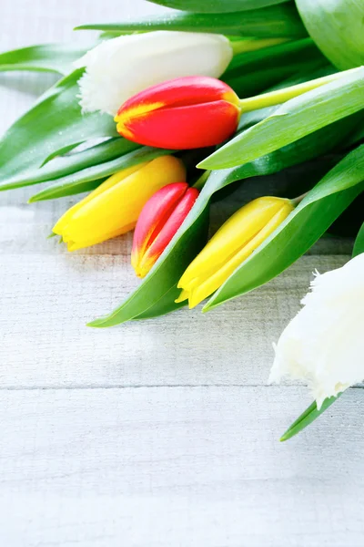 Brazo de tulipanes sobre fondo de madera — Foto de Stock