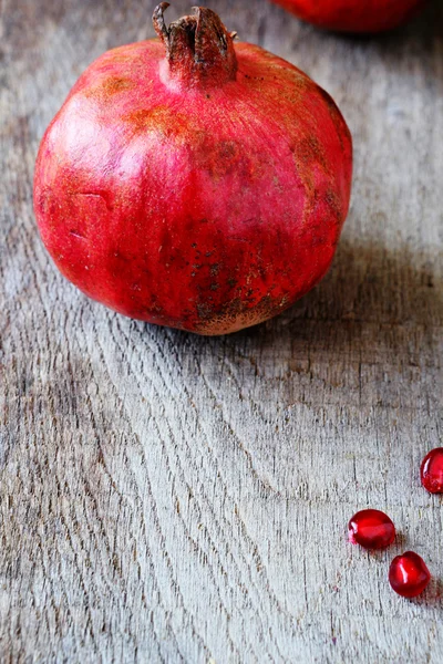 Rode granaatappel op het oude bord — Stockfoto