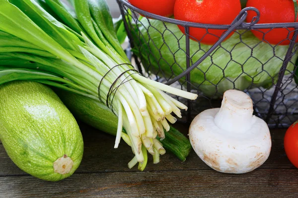 Свежие овощи на столе и в корзине — стоковое фото