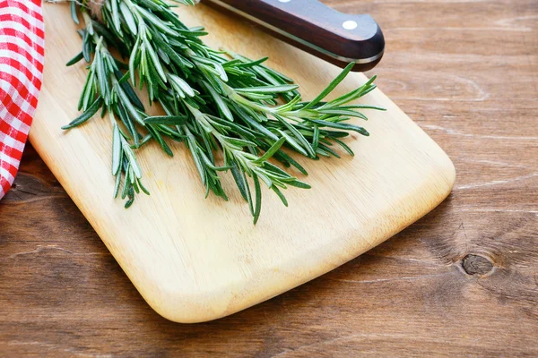 Rosmarino fresco su un'asse di cucina — Foto Stock