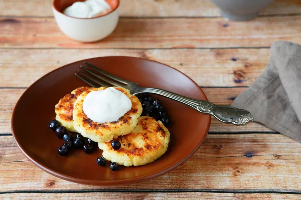 Cottage cheese pancakes with sour cream — Stock Photo, Image