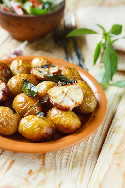 Gebackene neue Kartoffeln in ihren Schalen und Knoblauch — Stockfoto