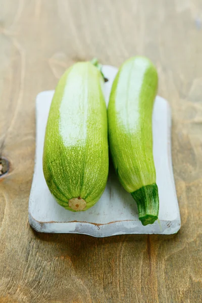 Deux courgettes vertes sur une planche — Photo