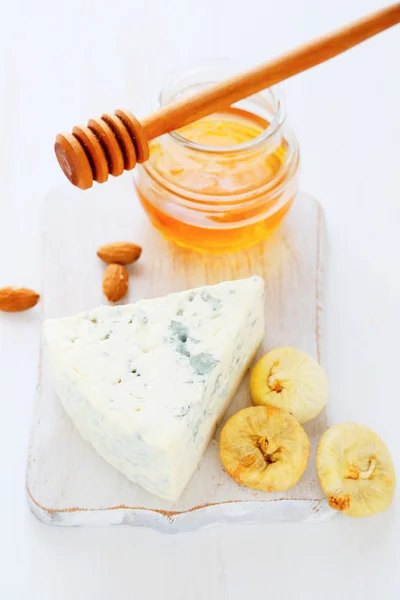 Queso, miel en una tabla blanca de cortar —  Fotos de Stock