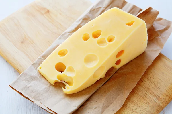 Pedaço de queijo com buracos — Fotografia de Stock