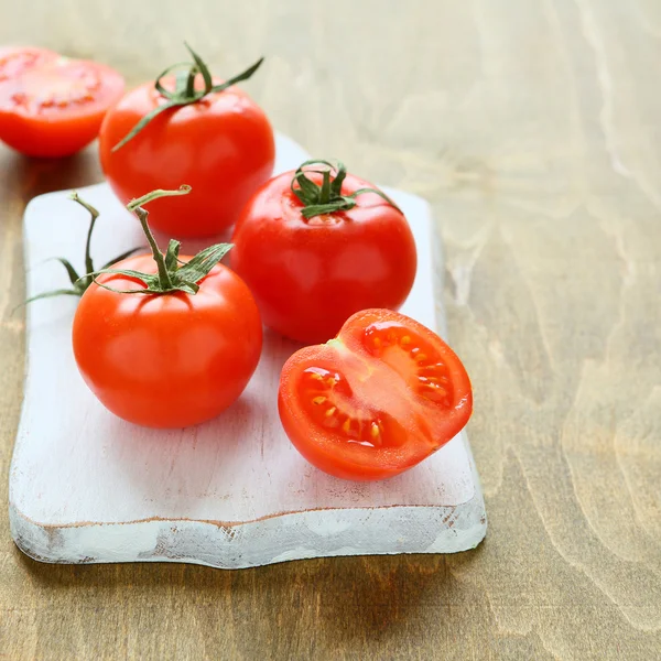 Rode tomaten op een keukenbord — Stockfoto