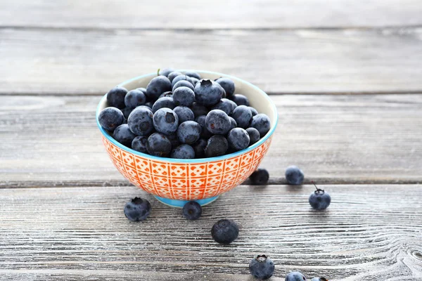 Blaubeeren in einer Schüssel auf einem Holztisch — Stockfoto