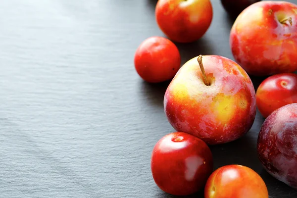 Ripe fresh plums on a stone plate — Stock Photo, Image