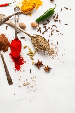 Kaşıklar üzerindeki baharat ve sos ve beyaz yüzey pişirme konsepti