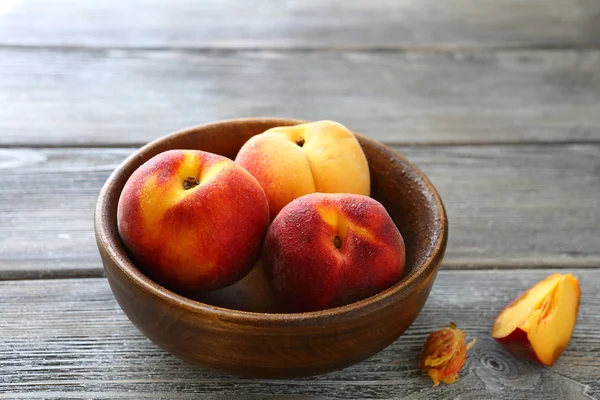 Three sweet peaches in a bowl — Stock Photo, Image