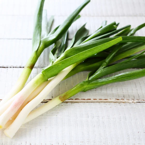 Fresh young garlic on white boards — Stock Photo, Image