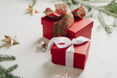 Beyaz yüzeyde iki kırmızı hediye kutusu tatil konsepti