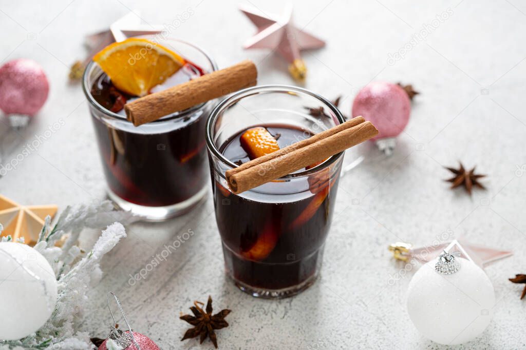 Two glass with mulled wine on light surface