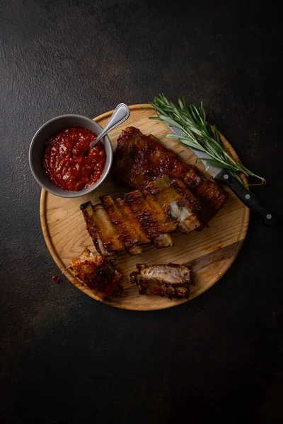 Overhead View Grilled Ribs Bbq Sauce Wooden Plate Dark Surface — Stock Photo, Image