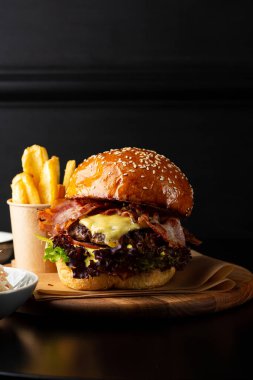 Peynirli pastırmalı burger ve patates kızartması yakın plan.