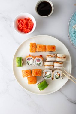 Beyaz tabakta hazırlanmış suşi rulolarının genel görünümü 
