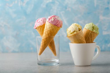 Dondurma kepçeleri gofret külahında dondurmanın mavi arka planı