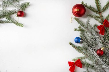 Yeşil dalları ve kırmızı süslemeleri olan Noel kompozisyonu hafif yüzey kopyalama alanı