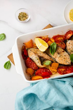 Roasted salmon steak with vegetables in baking dish food