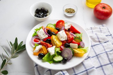  Fresh Greek salad o white plate mediterranean food on marble background