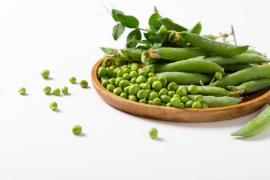Close up of plate with green peas pods and beans 