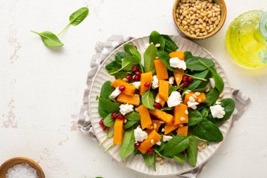 Beyaz tabakta kavrulmuş balkabağı ve feta salatası manzarası.