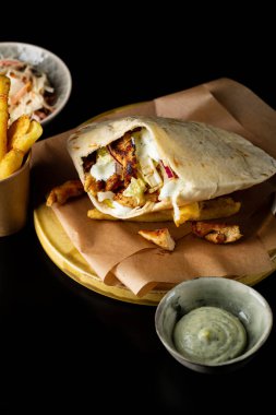 Pita 'ya sebze ve tavuk soslu patates koy.