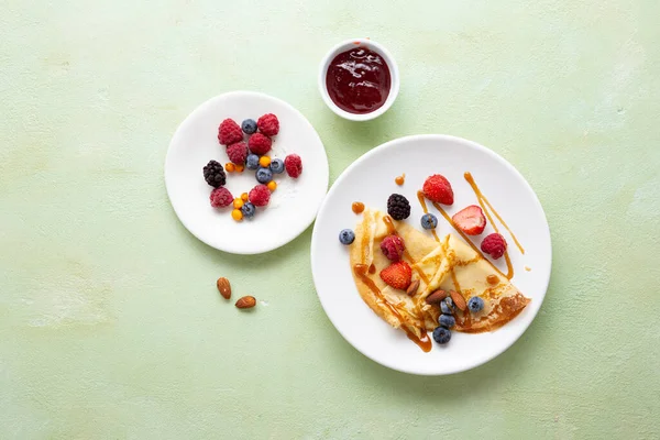 Overhead view of crepes with berries, jam and nuts food