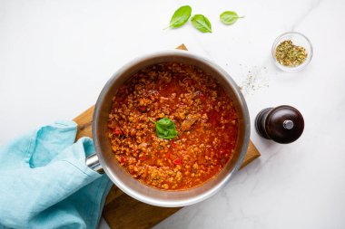 Kırmızı et sosunun mermer yüzeydeki bolonez ve baharatlı İtalyan yemeklerinin üst görüntüsü.