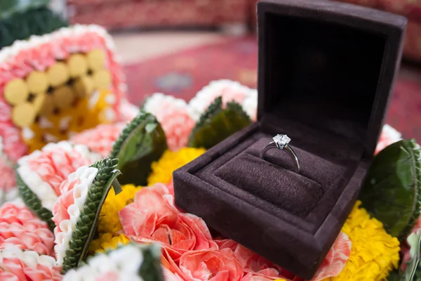 Un anillo de boda de diamantes en una caja abierta al estilo tailandés tradicional —  Fotos de Stock