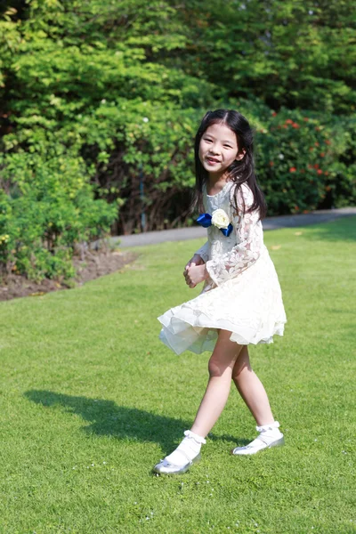 Roztomilá malá Asijská dívka v šťastně hráli v zahradě — Stock fotografie