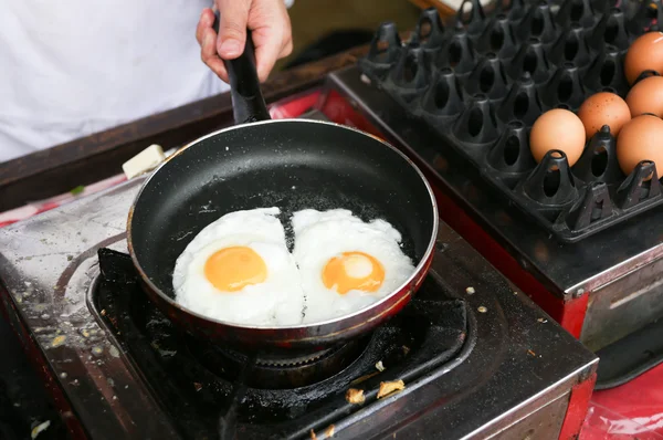 Seorang koki memasak telur-telur sisi cerah — Stok Foto