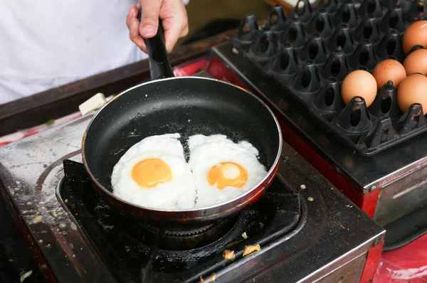 Een chef-kok is koken sunny side up eieren Rechtenvrije Stockafbeeldingen