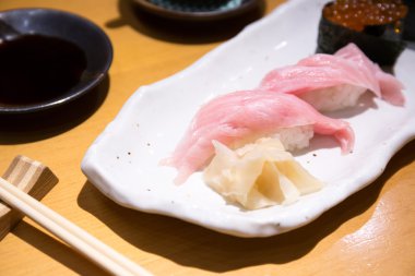 Beyaz tabakta yemek çubukları ile taze sushi