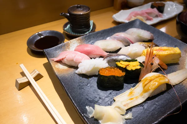 お箸で黒のプレートで新鮮な寿司 ロイヤリティフリーのストック画像
