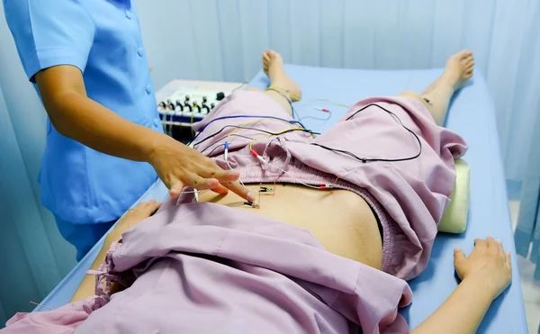 医師は、アジアの女性のための鍼治療をやっています。 ストックフォト