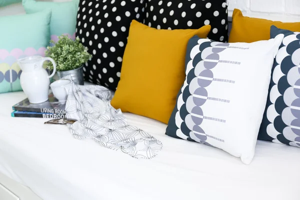 Almohadas de colores en un sofá con pared de ladrillo blanco en el fondo —  Fotos de Stock