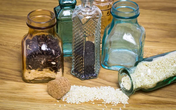 Sesami seed and rice in bottles — Stock Photo, Image