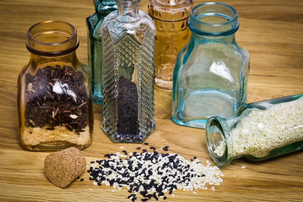 Sesami seed and rice in bottles — Stock Photo, Image