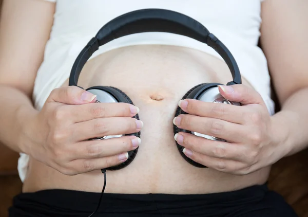 Zwangere vrouw luister naar de muziek — Stockfoto