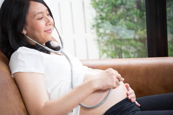 Zwangere vrouw met behulp van stethoscoop — Stockfoto