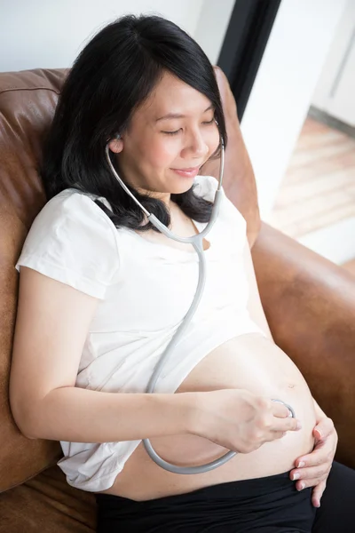 Zwangere vrouw met behulp van stethoscoop — Stockfoto