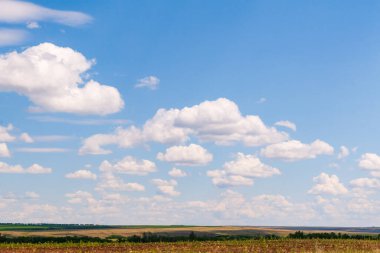Bozkır ufkunun üzerinde güzel bulutlar olan mavi gökyüzü manzarası.
