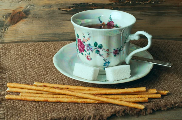 Cup of tea, sugar and bread sticks — Stock Photo, Image