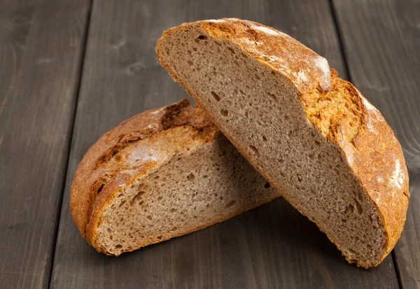 Cut loaf of bread on wood — Stock Photo, Image