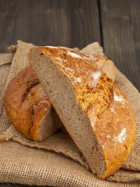 Cut loaf of bread on burlap — Stock Photo, Image