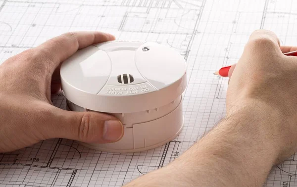 Man Planing Smoke Detector Fire Alarm Sensor White Architectural Plans — Foto de Stock