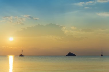 Boats and yachts at sunset clipart